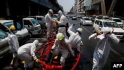 ရန်ကုန်မြို့ရှိ လမ်းများတွင် ပိုးသတ်ဆေးဖျန်းနေသည့် မီးသတ်တပ်ဖွဲ့ဝင်များ။ (ဧပြီ ၂၁၊ ၂၀၂၀)