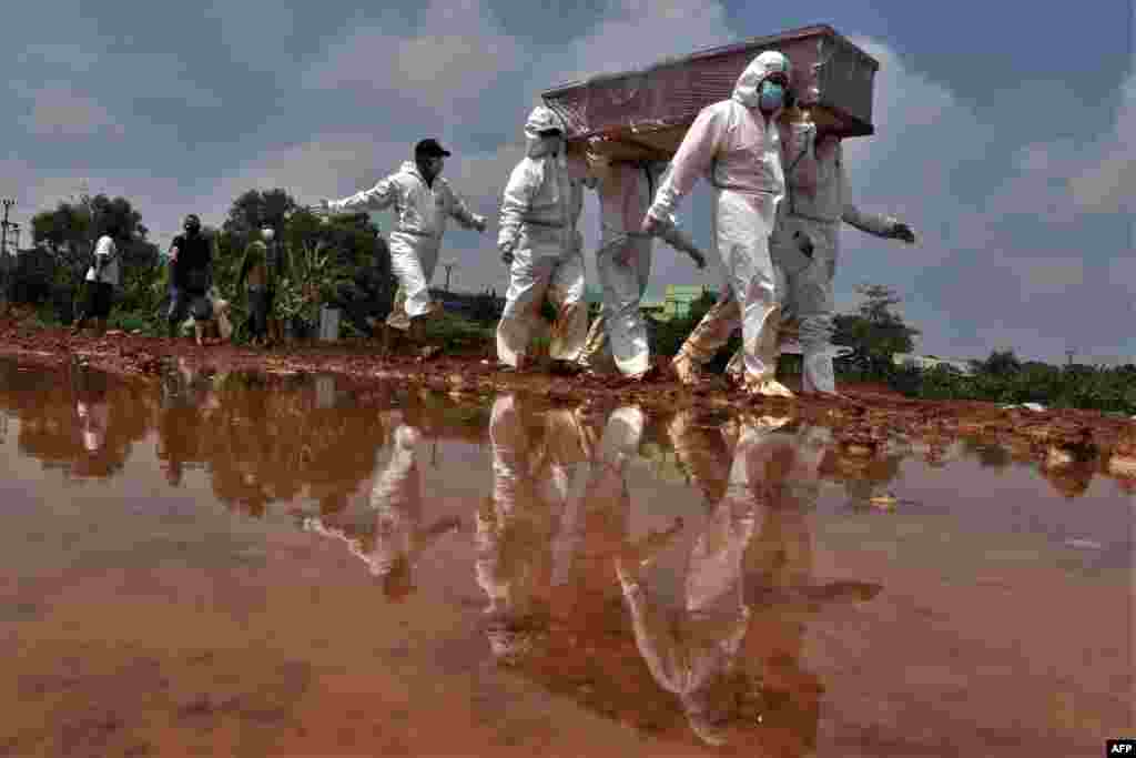Grave diggers carry the coffin of a victim who died from Covid-19 coronavirus for burial at a cemetery in Bekasi, Indonesia.