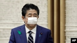 Wearing a protective mask, Japanese Prime Minister Shinzo Abe leaves a news conference at the prime minister's official residence in Tokyo, April 17, 2020.