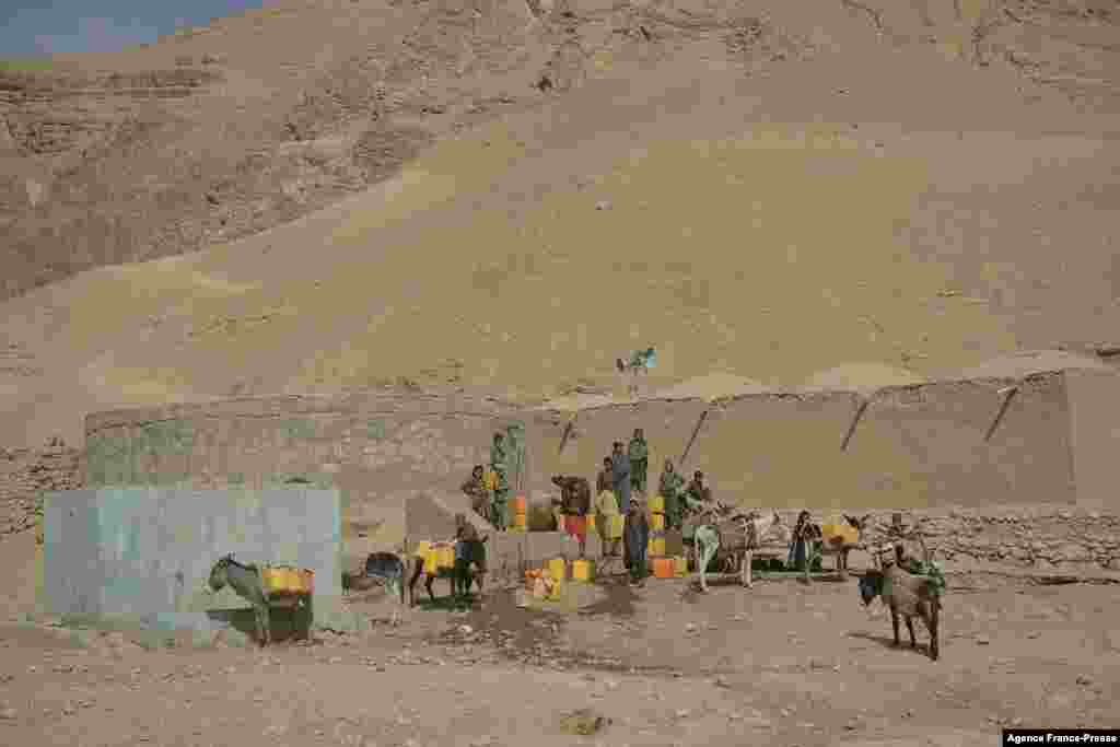 Children fill jerrycans with water from a water storage in Bala Murghab district of Badghis province, Afghanistan.