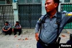 Police officers guard a Muslim residential area in Mandalay, Myanmar, July 3, 2014.