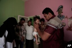 Staff weigh Galila, a 9-month old Yemeni girl who suffers from malnutrition and malaria, at the Stabilization Nutritional Therapeutic center in al-Khoukha, Yemen, Feb. 12, 2018.