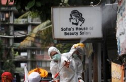 Seorang petugas Palang Merah Indonesia menyemprotkan carian disinfektan di kampung padat penduduk di tengah wabah virus corona (COVID-19) di Jakarta, 4 April 2020. (Foto: Reuters)