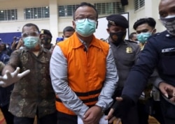 Menteri Kelautan dan Perikanan Edhy Prabowo, tengah, dikawal aparat keamanan berjalan usai jumpa pers di kantor Komisi Pemberantasan Korupsi (KPK) di Jakarta, Kamis, 26 November 2020. (Foto: AP)