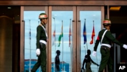 Flags of the member countries of the Association of Southeast Asian Nations (ASEAN) and their key dialogue partner nations are reflected on the glass doors of a conference hall, the venue for ASEAN and related meetings in Vientiane, Laos, Sunday, Sep 4, 2
