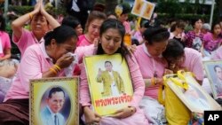 Thais cry as they pray for Thailand's King Bhumibol Adulyadej at Siriraj Hospital where the king is being treated in Bangkok, Thailand, Oct. 13, 2016.