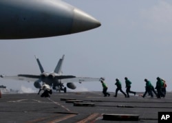 FILE - A U.S. Navy F-18 fighter jet takes off from the deck of the USS Carl Vinson (CVN 70) aircraft carrier following a routine patrol off the disputed South China Sea, March 3, 2017.