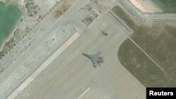 FILE - Satellite imagery shows the deployment of several new weapons systems, including a J-11 combat aircraft, at China’s base on Woody Island in the Paracels, South China Sea, May 12, 2018.