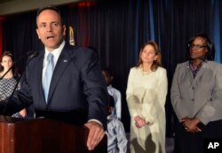 With his wife Glenna Bevin, center, and Lieutenant Governor-elect Jenean Hampton, right, looking on, Kentucky Republican Governor-elect Matt Bevin, speaks to his supporters at the Republican Party victory celebration, Tuesday, Nov. 3, 2015, in Louisville,