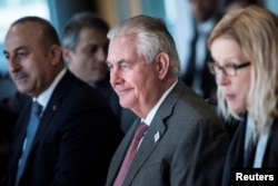 FILE - Secretary of State Rex Tillerson, center, sits with other diplomats before a meeting on Syria in Bonn, Germany, Feb. 17, 2017.