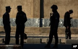FILE - Afghan National police stand at the site of a suicide attack near the Defense Ministry compound, in Kabul, Afghanistan.