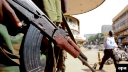 Un officier de la police ougandaise monte la garde sur une rue au centre-ville de Kampala, en Ouganda, 20 février 2011.