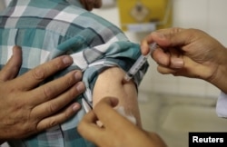 A health agent vaccinates a man during a campaign of vaccination against yellow fever in Sao Paulo, Brazil, Jan. 17, 2018.