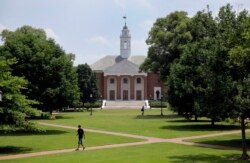 In this July 8, 2014 picture, people walk on Johns Hopkins University's Homewood campus in Baltimore.