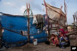 Awsaf, a 5-year-old Yemeni girl, eats bread and drinks tea - which on many days is the only food she has - next to her mother in their hut in Abyan, Yemen, Feb. 15, 2018.