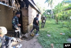 Police and soldiers take position as they engage with the Abu Sayyaf group in the village of Napo, Inabanga town, Bohol province, in the central Philippines on April 11, 2017.