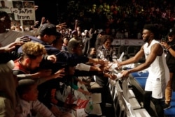 FILE - Team World's Jaylen Brown of Boston Celtics, gives away his shoes after playing the NBA Africa Game between Team Africa and Team World, at the Dome in Johannesburg, South Africa.