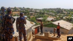 រូបឯកសារ៖ សន្តិសុខនិយាយទៅកាន់មនុស្សពីរនាក់នៅជំំរំ Cox's Bazar ក្នុងប្រទេសបង់ក្លាដេស កាលពីថ្ងៃទី១៥ ខែឧសភា ឆ្នាំ២០២០។ 