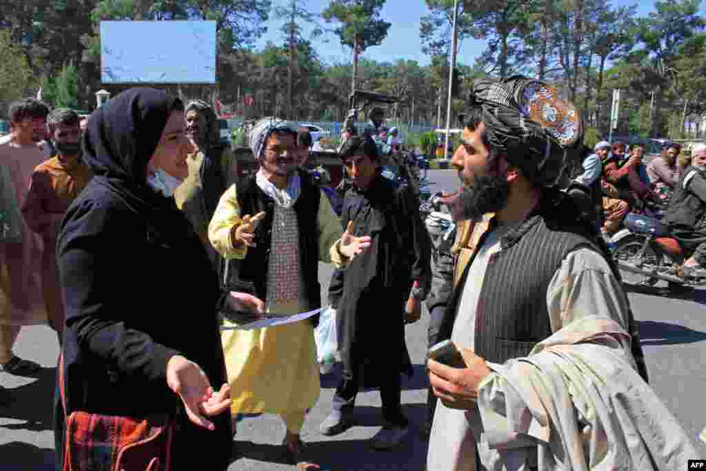 An Afghan woman protester speaks with a member of the Taliban during a protest in Herat.