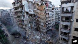 Bulldozers remove the rubble of a destroyed building that was hit Sunday night in an Israeli airstrike in Dahiyeh, in the southern suburb of Beirut, Lebanon, Nov. 25, 2024.