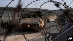 以色列士兵站在叙利亚与被以色列占领的戈兰高地之间阿尔法线旁的军车旁。(2024年12月9日)