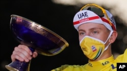 Tour de France winner Slovenia's Tadej Pogacar, wearing the overall leader's yellow jersey, celebrates on the podium after the twenty-first and last stage of the Tour de France cycling race over 122 km, from Mantes-la-Jolie to Paris, Sept. 20, 2020.