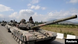 FILE - A Georgian tank moves along a road near the city of Tskhinvali, 100 km (62 miles) from Tbilisi, Aug. 8, 2008. 