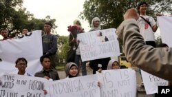 FILE - A Sept. 2014 photo shows protesters holding posters during a rally against the Islamic State group, in Jakarta, Indonesia.
