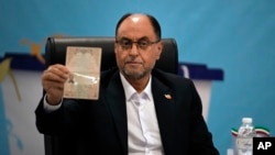 Vahid Haghanian, a former commander in the Revolutionary Guards, shows his identification document to the media while registering his name as a candidate for the June 28 presidential election at the Interior Ministry in Tehran, Iran, on June 1, 2024.