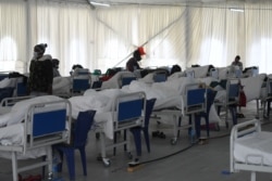 FILE - Coronavirus patients rest on their beds at the isolation ward at the Kenyatta stadium where screening booths and an isolation field hospital are installed to aid with COVID-19 patients in Machakos, Kenya, July 28, 2020.