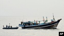 En esta foto divulgada por la Marina de EEUU, miembros del USS Tempest y el USS Typhoon se acercan a un barco apátrida que transportaba drogas en aguas internacionales en el Mar Arábigo, el 27 de diciembre de 2021.