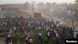 People scramble in Nzerekore, Guinea, where local officials said a deadly stampede ensued at a stadium following fan clashes during a soccer match, December 1, 2024, in this still image obtained from a social media video. (Social media via REUTERS)
