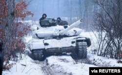 Service members of the Ukrainian Armed Forces ride atop of a tank during military drills in the Donetsk region, Ukraine, in this handout picture released Feb. 4, 2022. (Press service of the Joint Forces Operation/Handout via Reuters)
