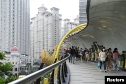 Para pejalan kaki mengenakan masker di tengah pandemi COVID-19, saat berjalan di jembatan salah satu pusat perbelanjaan di Jakarta, 30 Oktober 2021. (REUTERS/Ajeng Dinar Ulfiana)