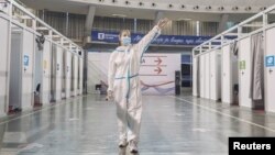 Medicinska radnica - volonterka usmerava ljude koji treba da prime drugu dozu vakcine protiv Kovida 19 proizvođača Fajzer-BioNTek, u Hali 3 Beogradskoj sajma, u Beogradu, 13. aprila 2021. (Foto: Rojters, Marko Đurica)