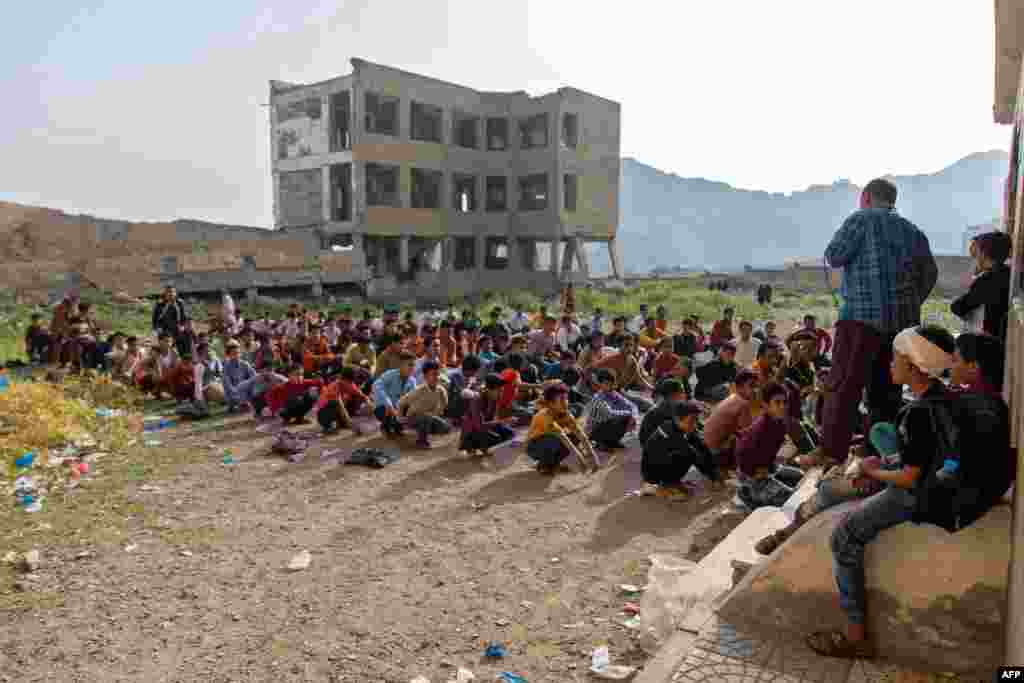 Yemeni students attend class in their destroyed school compound on the first day of the new academic year in the country's third-city of Taez.
