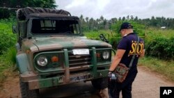 Police inspect a vehicle at a military checkpoint where a bomb exploded in Lamitan, Basilan province, southern Philippines, July 31, 2018.