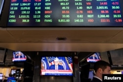 FILE - A trader works inside a booth, as screens display a news conference by Federal Reserve Board Chairman Jerome Powell following the Fed rate announcement, on the floor of the New York Stock Exchange (NYSE) in New York City, U.S., May 1, 2024. (REUTERS/Stefan Jeremiah)