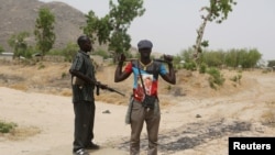 Des membres d'un groupe de vigilance tiennent la garde à la frontière avec le Nigeria à Kerawa, au Cameroun, le 16 mars 2016.