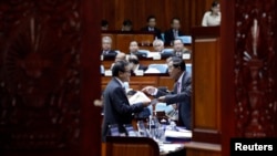 Cambodia's Prime Minister Hun Sen (R) talks to Sam Rainsy, president of the Cambodia National Rescue Party (CNRP), during a plenary session at the National Assembly in Phnom Penh November 28, 2014. REUTERS/Samrang Pring 