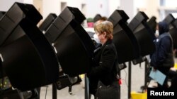 FILE - Voters cast their ballots for the presidential primary elections at the Franklin County Board of Election office in Columbus, Ohio, April 28, 2020.