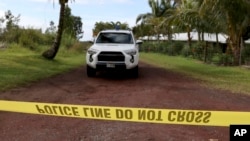 A police office blocks a road near lava fissure 17 after it erupted May 13 2018 near Pahoa, Hawaii.