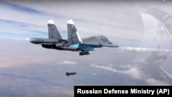 FILE - A bomb is released from Russian Su-34 strike fighter in Syria, Oct. 9, 2015.