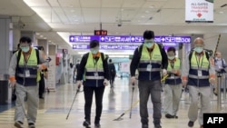 戴著口罩的工作人員在台北桃園機場噴灑消毒藥水防範新冠病毒。（2020年1月22日）