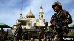 Government troops walk past a mosque before their assault on insurgents from the so-called Maute group, who have taken over large parts of Marawi City, southern Philippines, May 25, 2017.
