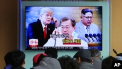 FILE - People watch a TV screen showing images of North Korean leader Kim Jong Un, right, South Korean President Moon Jae-in, center, and U.S. President Donald Trump at the Seoul Railway Station in Seoul, South Korea, March 7, 2018.