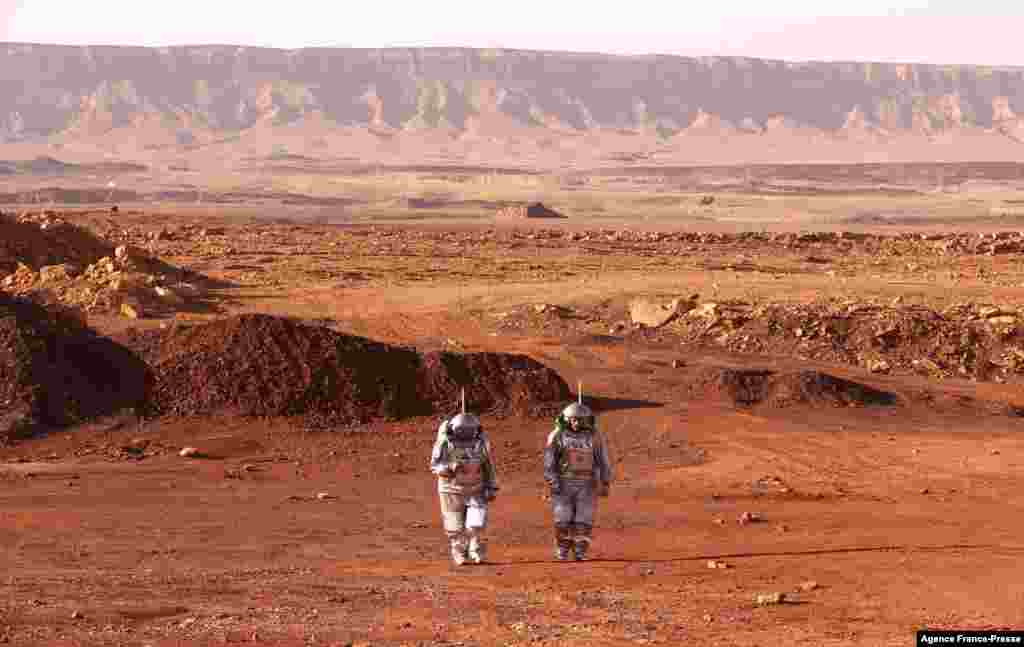 Astronauts from Europe and Israel walk in spacesuits during a training mission for planet Mars at a site that simulates an off-site station at the Ramon Crater in Mitzpe Ramon in Israel's southern Negev desert, Oct. 10, 2021.