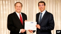 Adam Aron, CEO and President, AMC, left, and His Excellency Dr. Awwad Alawwad, Saudi Arabia's Minister of Culture and Information pose with a cinema license to open and operate cinemas in Saudi Arabia on April 4, 2018, in Los Angeles.