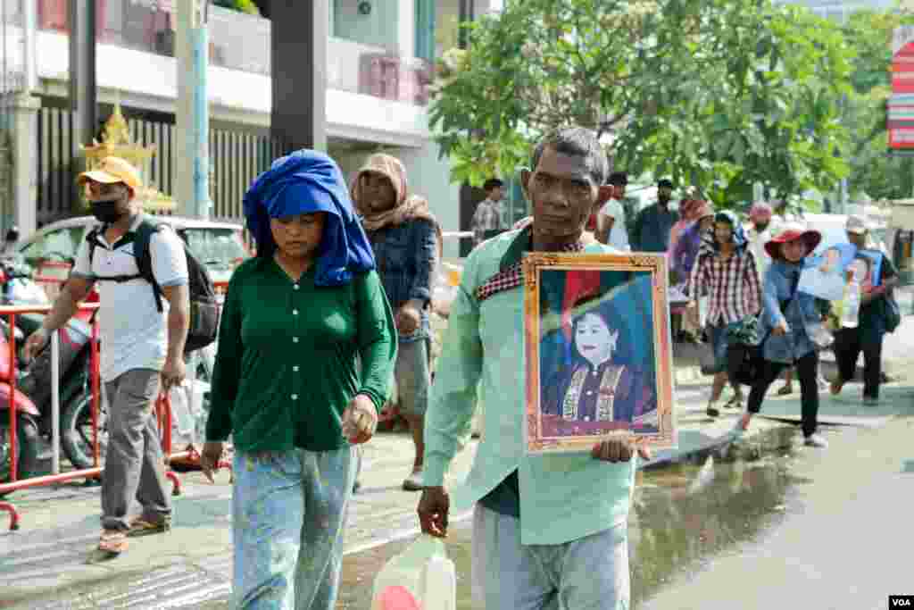 ប្រជាពលរដ្ឋ​មកពី​ខេត្ត​ក្រចេះ​កាន់​រូប​ភរិយា​របស់​នាយករដ្ឋ​មន្រ្តី​កម្ពុជា លោក ហ៊ុន សែន ក្នុង​ការ​ហែ​ក្បួ​ន​បាតុកម្មទាក់ទិន​នឹង​ជម្លោះ​ដី​ធ្លី នៅ​ក្បែរ​គេហដ្ឋាន​របស់​នាយក​រដ្ឋមន្រ្តី​កម្ពុជា​លោក​​​ ហ៊ុន សែន កាលពី​ថ្ងៃទី​២៣ មេសា ឆ្នាំ​២០១៨។​ (ទុំ ម្លិះ/VOA)