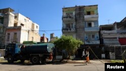 Un hombre sostiene una manguera mientras entrega agua desde un camión cisterna, en La Habana, Cuba, 9 de septiembre de 2024. REUTERS/Norlys Pérez